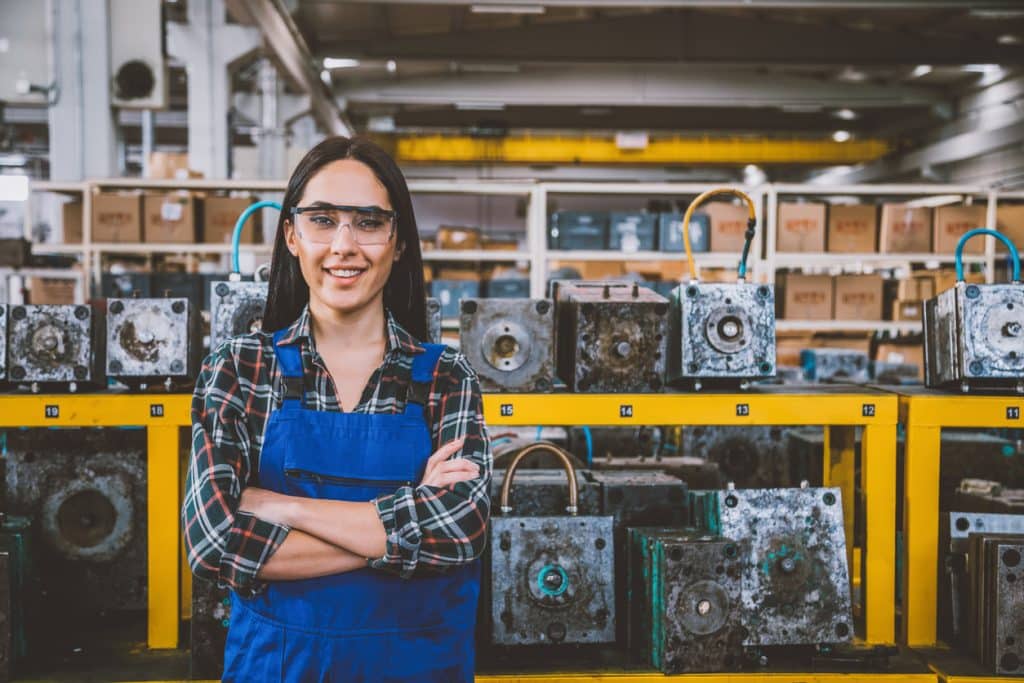 Portrait of smiling young technician woman in factory