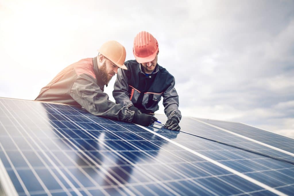 Workers Measuring Photovoltaic Cells Dimensions Of Solar Panel